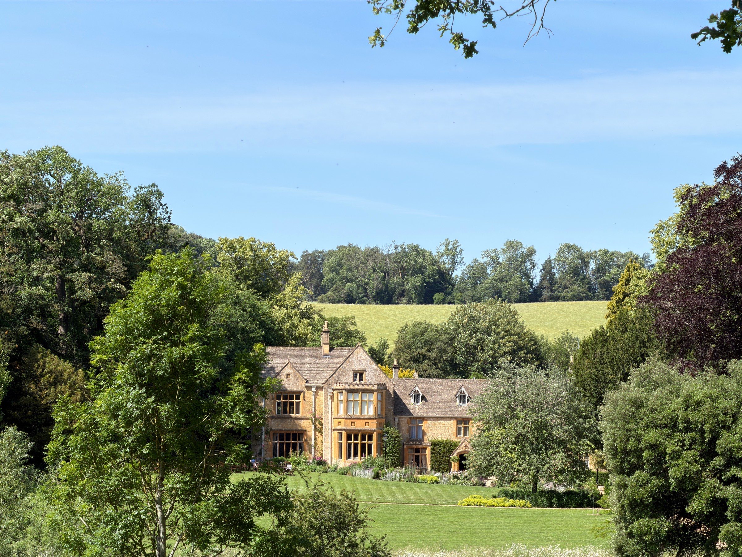 A historic English country house manor set among trees and lawns