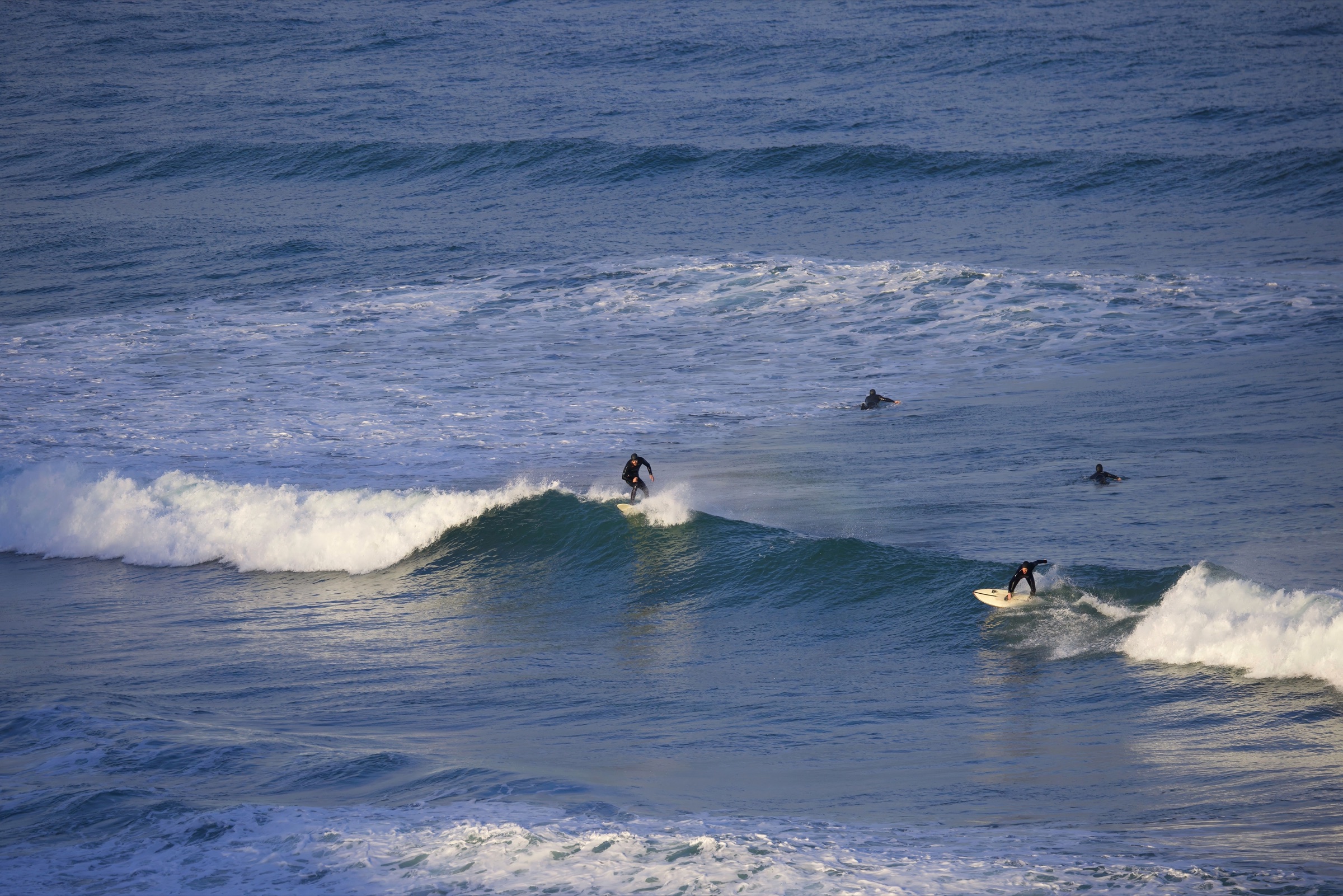Surfers in the water at Watergate Bay, on Cornwall's exposed Atlantic north coast