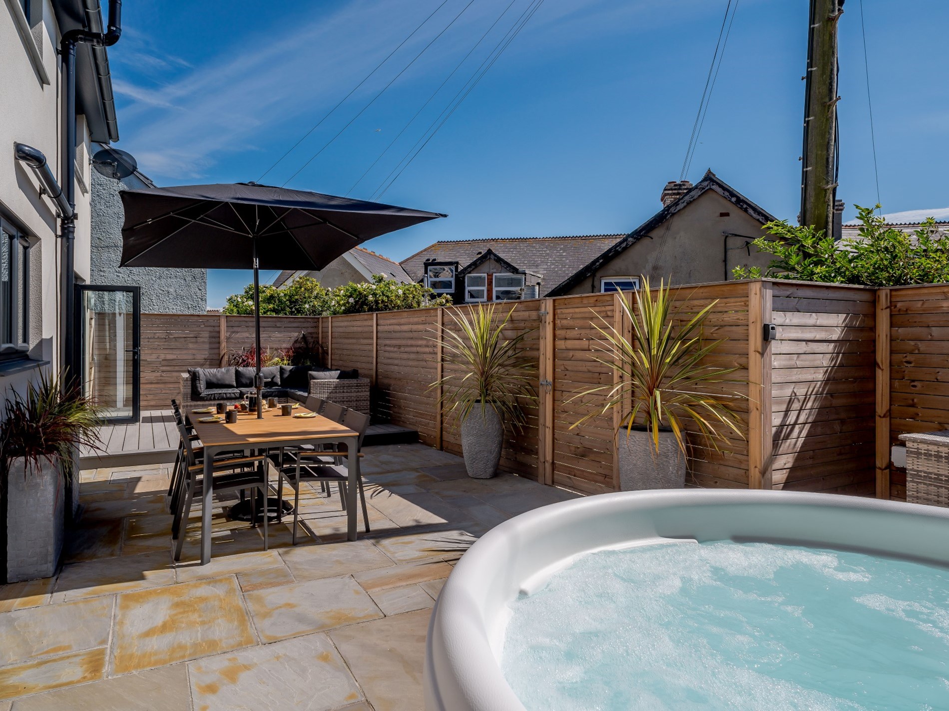 The enclosed garden with hot tub and sea glimpses at The Bude Coastal House, Bude