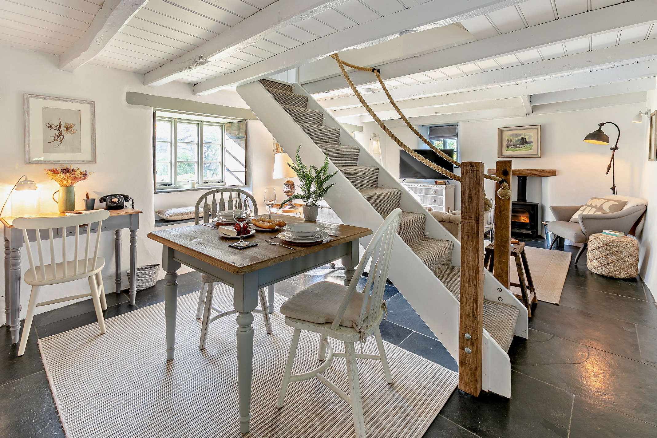The open-plan interior at The Looe Cottage with slate flooring and beamed ceiling