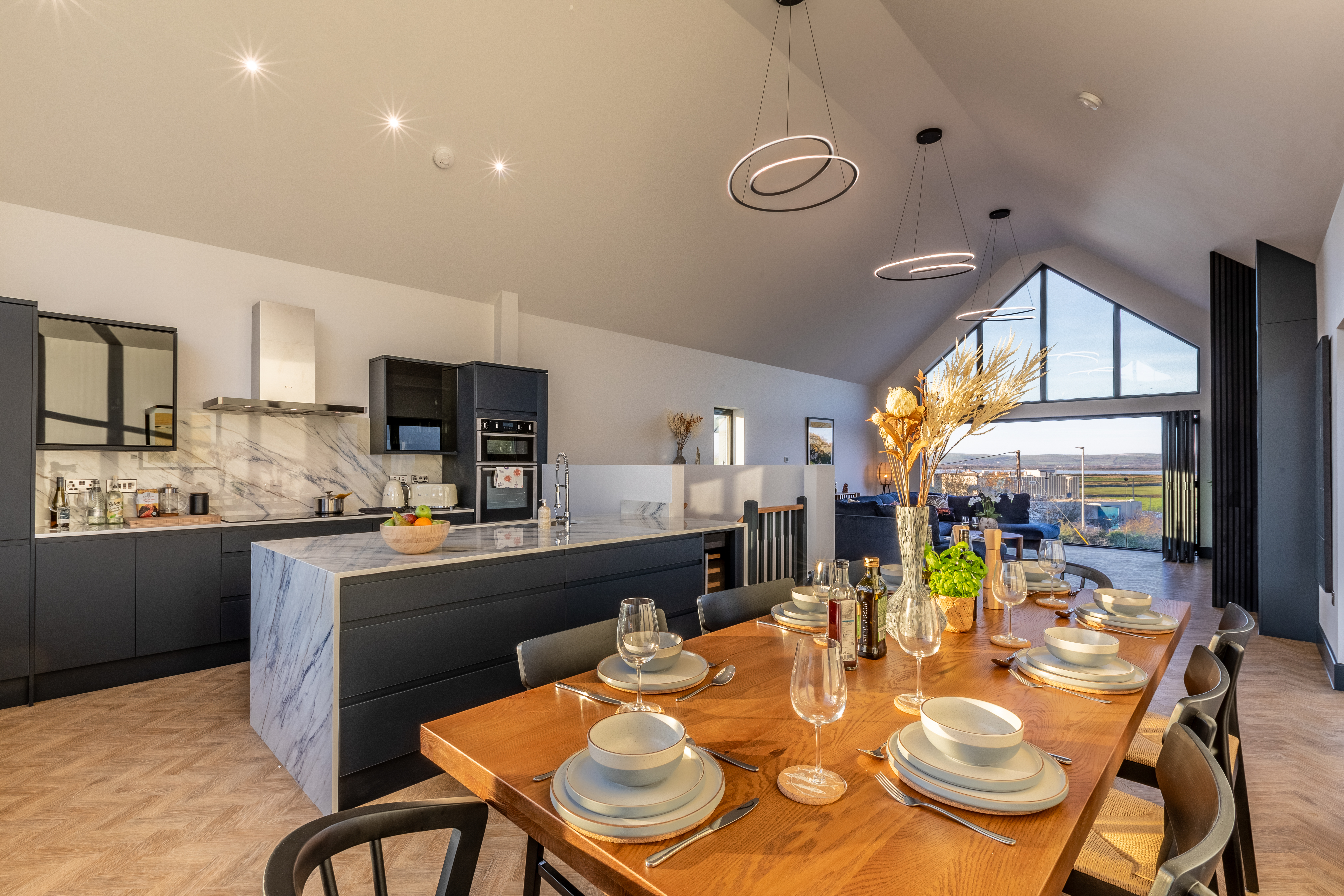 The contemporary open-plan kitchen with breakfast bar at The Estuary House
